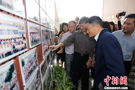 圖為馬云參觀學(xué)校圖片展覽。　資料圖 攝